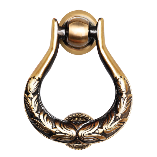 A gold-colored, intricately designed brass door knocker with a black and gold finish.