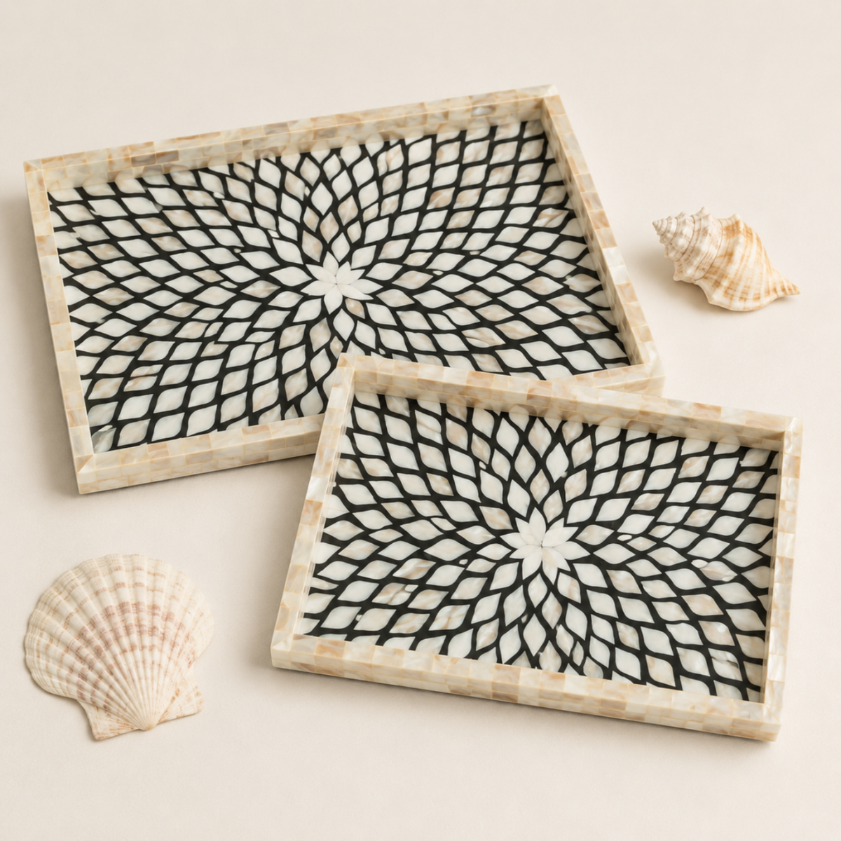 Two rectangular decorative trays with a black geometric web-like pattern on a white background and a natural beige shell-look border, styled with seashells on a light beige surface.