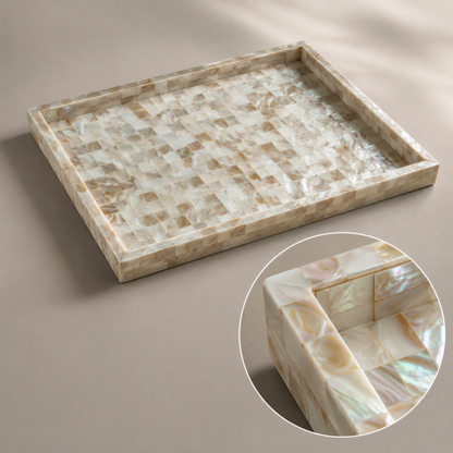 A rectangular decorative tray made of iridescent mother-of-pearl shell tiles, shown on a neutral taupe background with a circular inset close-up highlighting the shell texture.