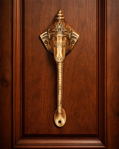 Decorative Antique ganesha brass door handle on a wooden door.