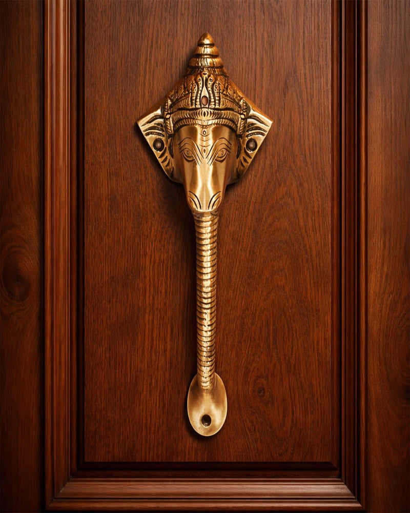 Decorative Antique ganesha brass door handle on a wooden door.