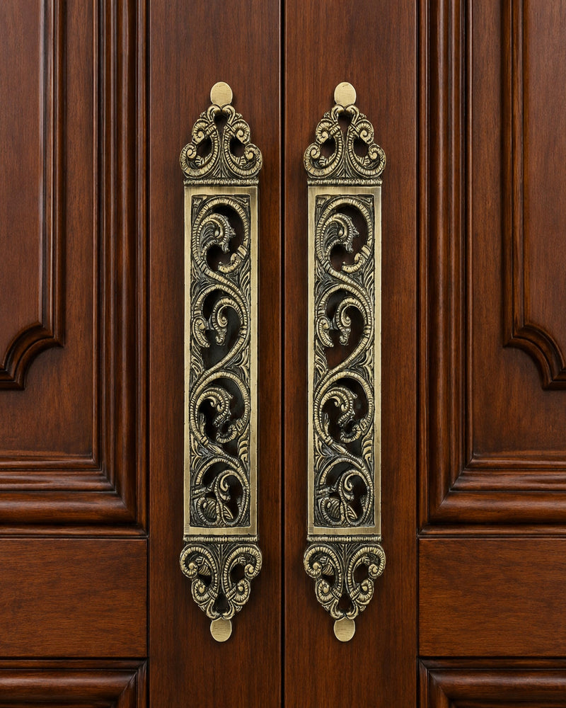 Decorative Brass door pull handles on a wooden door.