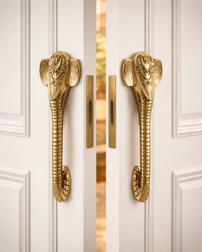 Golden Ganesha door handles on a white door.