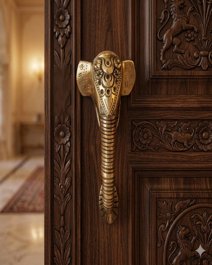 Decorative brass handle on a wooden door.