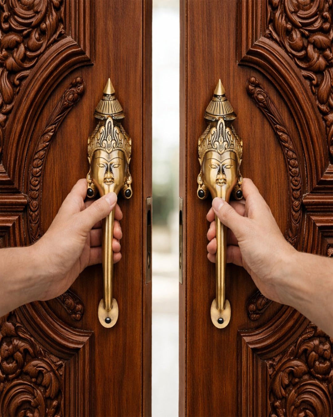 Two hands opening a wooden door with ornate carvings and gold handles featuring facial designs.