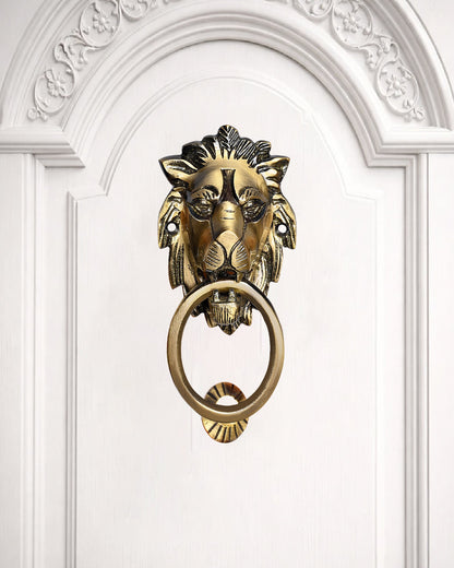 Gold lion-shaped door knocker on a white door