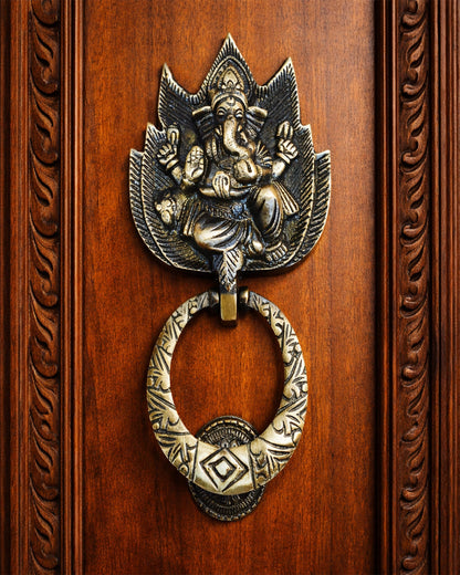 Decorative door knocker with Ganesha figure on a wooden door