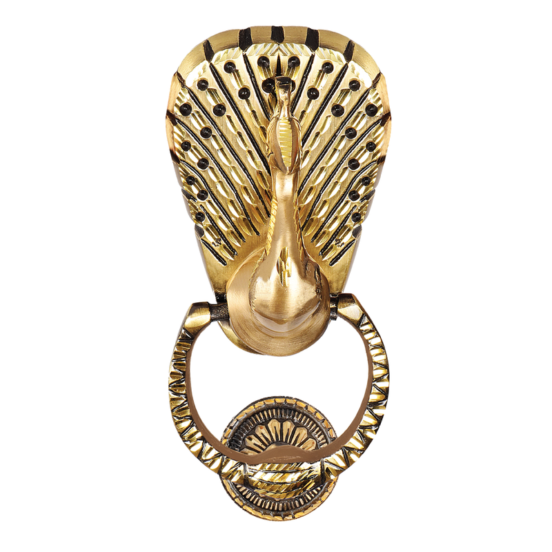 A gold-colored brass door knocker featuring an intricate peacock feather design, with a visible hinge and strike plate.