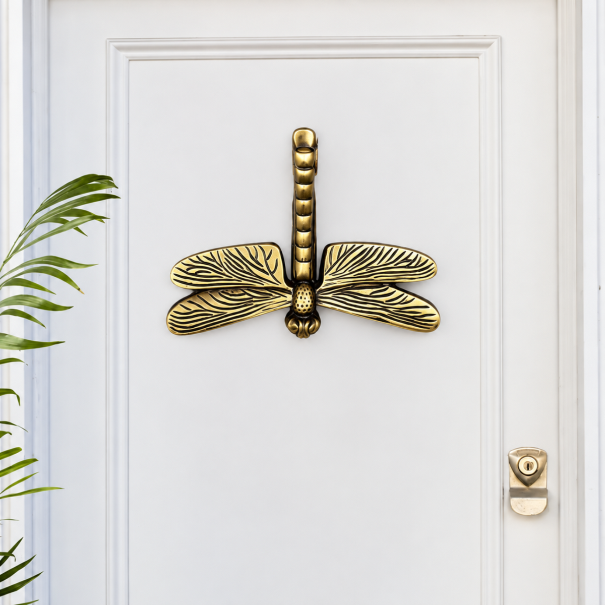 Decorative Vintage Dragonfly Brass Door Knocker on white background.